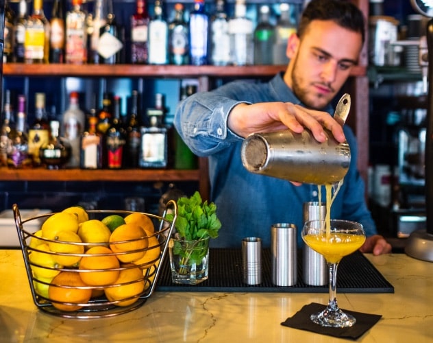 Bartender pouring cocktail.